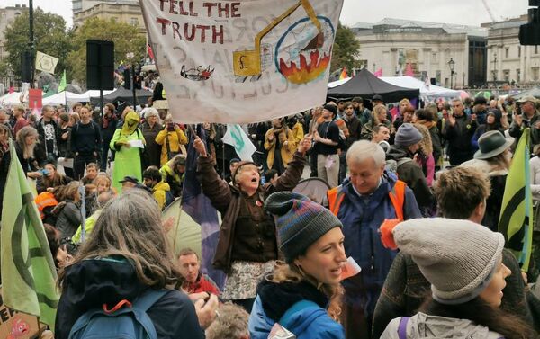 An activist holds a banner on climate change as protestors stage a sit in at a major road at Trafalgar Square in London, UK - Sputnik International