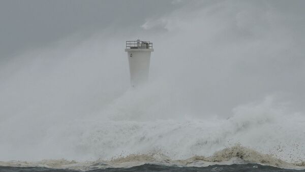 Surging waves hit against the breakwater and a lighthouse as Typhoon Hagibis approaches at a port in the town of Kiho, Mie prefecture, central Japan. - Sputnik International