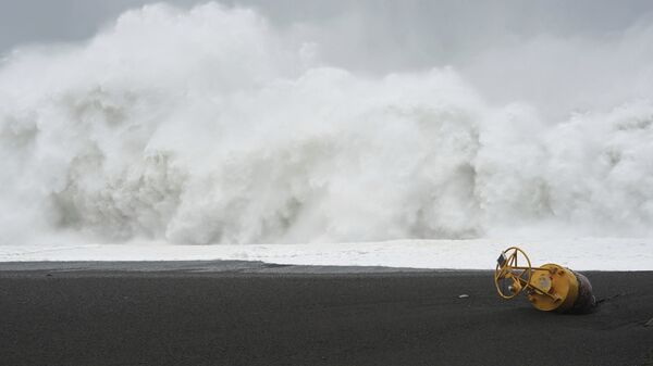 A buoy lies on a beach is seen in front of surging waves as Typhoon Hagibis approaches in Kumano, Mie prefecture, central Japan Saturday - Sputnik International