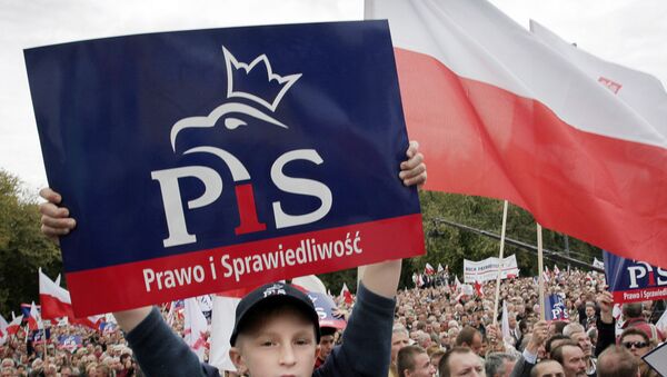 A Polish boy holds a poster showing the logo of the Law and Justice (PiS) party (File) - Sputnik International