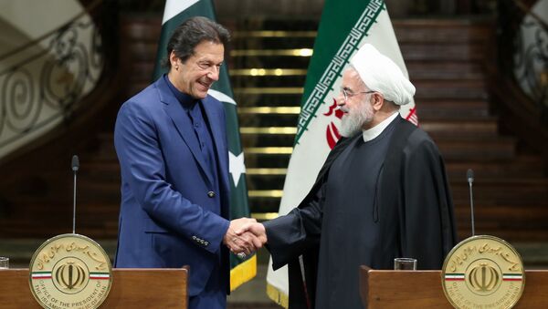 Iranian President Hassan Rouhani shakes hands with Pakistani Prime Minister Imran Khan during a news conference in Tehran, Iran, October 13, 2019 - Sputnik International