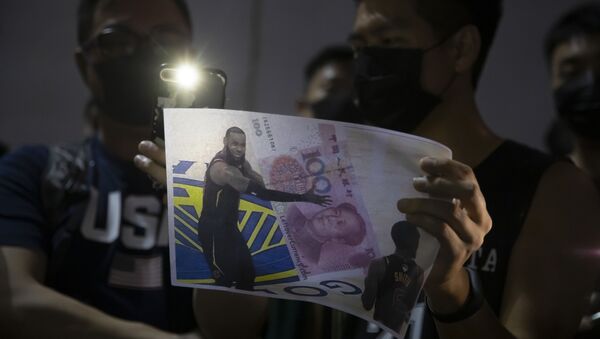 A demonstrator holds a sign showing Lebron James embracing a Chinese 100-yuan banknote during a rally at the Southorn Playground in Hong Kong, Tuesday, Oct. 15, 2019 - Sputnik International