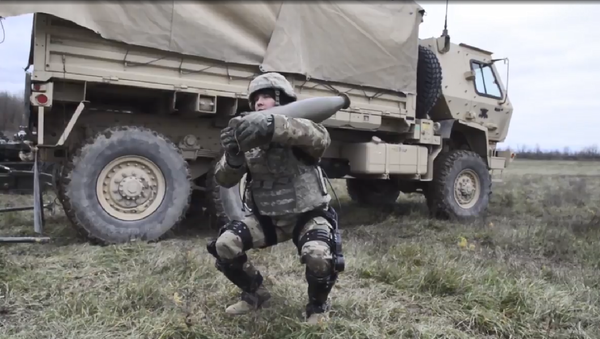 A US soldier demonstrates the Onyx lower-body exoskeleton by lifting an artillery shell - Sputnik International