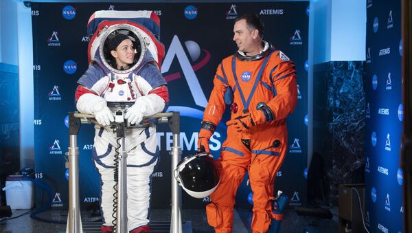 The two NASA spacesuit ​prototypes for lunar exploration, one for launch and re-entry aboard the agency's Orion spacecraft, known as the Orion Crew Survival Suit, is worn by Dustin Gohmert, right, and one for exploring the surface of the Moon's South Pole, known as the Exploration Extravehicular Mobility Unit (xEMU) is worn by Kristine Dans on Tuesday, Oct. 15, 2019, at NASA Headquarters in Washington - Sputnik International