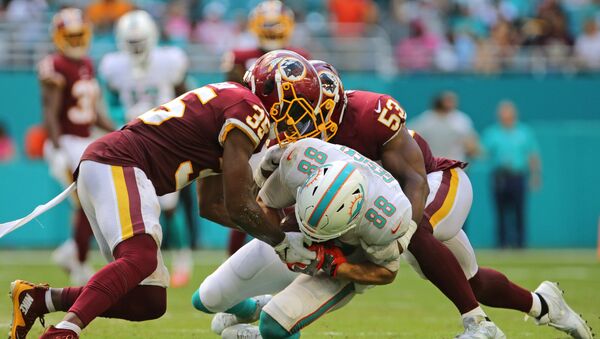 Oct 13, 2019; Miami Gardens, FL, USA; Miami Dolphins tight end Mike Gesicki (88) carries the ball and gets tackled by Washington Redskins strong safety Montae Nicholson (35) and linebacker Jon Bostic (53) during the fourth quarter of the game at Hard Rock Stadium. - Sputnik International