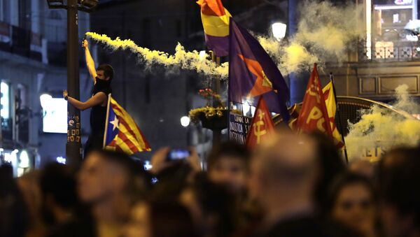 A protestor burns a flare as a pro-independence Estelada flag is waved in Puerta del Sol square in Madrid, Spain, Wednesday, Oct. 16, 2019.  - Sputnik International