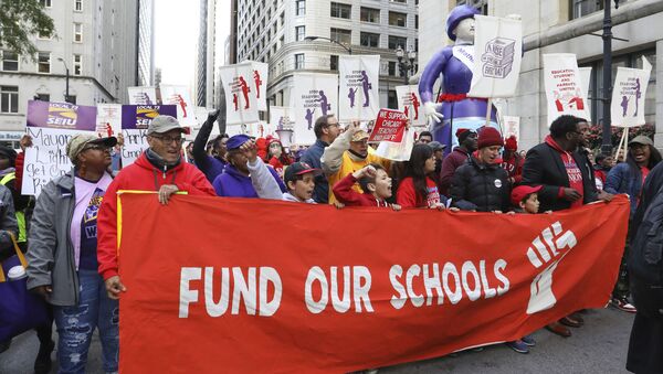 Teachers, staff and their supporters march through downtown Chicago, Monday, Oct. 14, 2019. The teachers are calling for district leaders to meet their demands on class sizes just days before a threatened strike that would affect thousands of students in the country's third-largest school district.  - Sputnik International