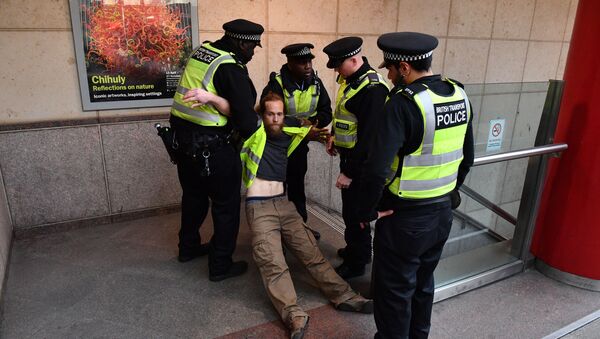 Police remove a protestor who had glued himself to the window of a DLR train at Canary wharf station on the third day of an environmental protest by the Extinction Rebellion group (File) - Sputnik International