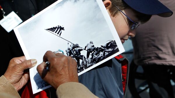 An Iwo Jima veteran signs autograph on the famous WWII photograph Raising the Flag on Iwo Jima shot by AP photographer Joe Rosenthal for Michael Scott of Altoona, Pennsylvania, at a ceremony to mark the 65th anniversary of the battle of Iwo Jima February 19, 2010 at the National Museum of Marine Corps in Triangle, Virginia - Sputnik International