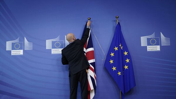 An official hangs a Union Jack next to an European Union flag at EU Headquarters in Brussels on October 17, 2019, ahead of a European Union Summit on Brexit. - Sputnik International
