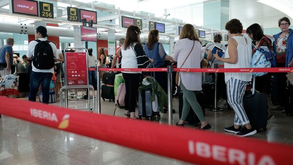 Passengers queue in front of check-in counters of Spanish airline Iberia at Barcelona's 'El Prat' airport on July 27, 2019 - Sputnik International