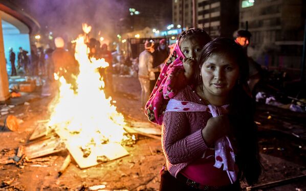 A woman and her daughter pose as indigenous people celebrate outside the Casa de la Cultura in Quito on October 13, 2019 after Ecuador's president and indigenous leaders reached an agreement to end violent protests. - Ecuador's president and indigenous leaders reached an agreement to end nearly two weeks of violent protests against austerity measures put in place to obtain a multi-billion-dollar loan from the IMF. President Lenin Moreno met with Jaime Vargas, the head of the indigenous umbrella grouping CONAIE, for four hours of talks in the capital Quito broadcast live on state television.  - Sputnik International