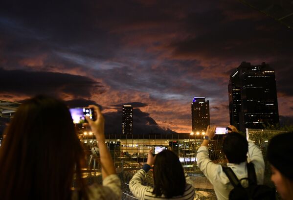 People take photos during sunset near Osaka Station, as typhoon 'Hagibis' approaches Japan, in Osaka, Japan October 12, 2019.  - Sputnik International