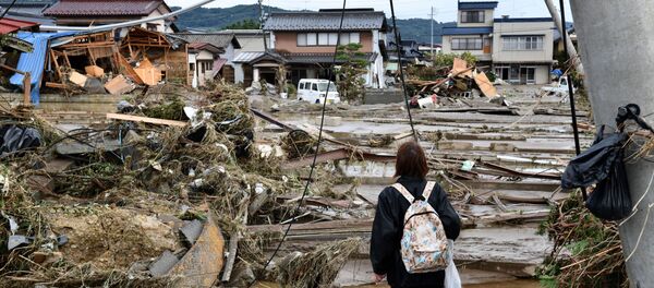A woman looks at flood-damaged homes in Nagano on October 15, 2019, after Typhoon Hagibis hit Japan on October 12 unleashing high winds, torrential rain and triggered landslides and catastrophic flooding. - Rescuers in Japan worked into a third day on October 15 in an increasingly desperate search for survivors of a powerful typhoon that killed nearly 70 people and caused widespread destruction. A woman looks at flood-damaged homes in Nagano on October 15, 2019, after Typhoon Hagibis hit Japan on October 12 unleashing high winds, torrential rain and triggered landslides and catastrophic flooding. - Rescuers in Japan worked into a third day on October 15 in an increasingly desperate search for survivors of a powerful typhoon that killed nearly 70 people and caused widespread destruction. - Sputnik International