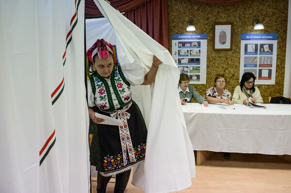 Sporting a traditional dress Piroska Kovacsne Bablena exits the ballot booth after voting in the nationwide local elections, in the village of Rimoc, Hungary, Sunday, Oct. 13, 2019.  - Sputnik International