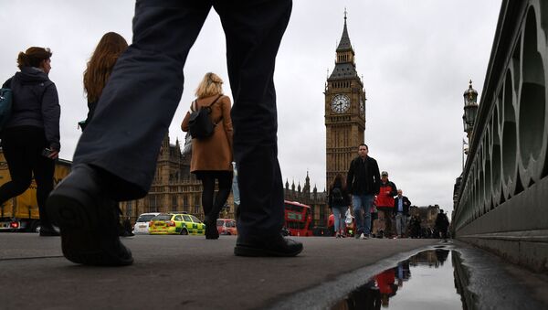 In this file photo taken on March 29, 2017 Commuters walks over Westminster bridge by the Houses of Parliament in central London on March 29, 2017. - Sputnik International