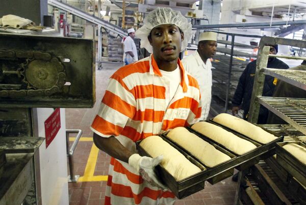 Inmate Nikos Alexis loads fresh dough into an oven at the Rikers Island jail bakery. He was part of a team of 20 inmates who earned some money baking thousands loaves of bread to feed a huge number of prisoners – in 2011 there were about 13,000 men and women behind bars.   - Sputnik International
