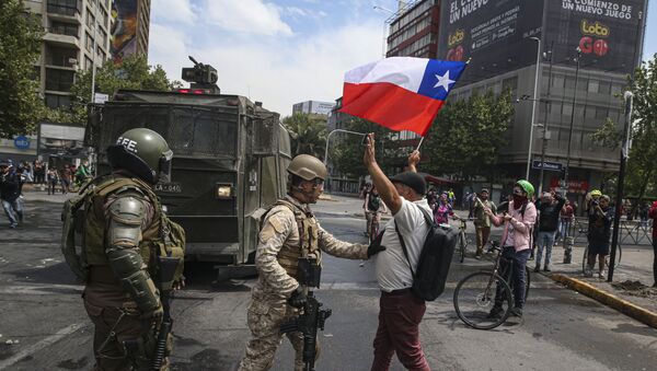   Army soldiers stop a man protesting with a Chilean flag, after a night of riots that forced President Sebastian Pinera to announce a state of emergency, in Santiago, Chile, Saturday, Oct. 19, 2019. - Sputnik International