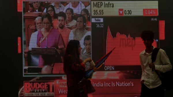 People walk as a telecast of India's Finance Minister Nirmala Sitharaman presenting the budget is displayed inside the Bombay Stock Exchange (BSE) building in Mumbai, India, July 5, 2019. - Sputnik International