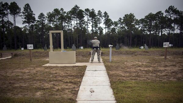 A member of the 139th Military Police Company shoots his 9mm Beretta M9, during a qualifying exercise at a range, Tuesday, Sept. 29, 2015, in Fort Stewart, Ga.  The Army wants to replace its M9, a 9mm semi-automatic handgun adopted during the Cold War. The new gun also will replace the smaller M11.  - Sputnik International