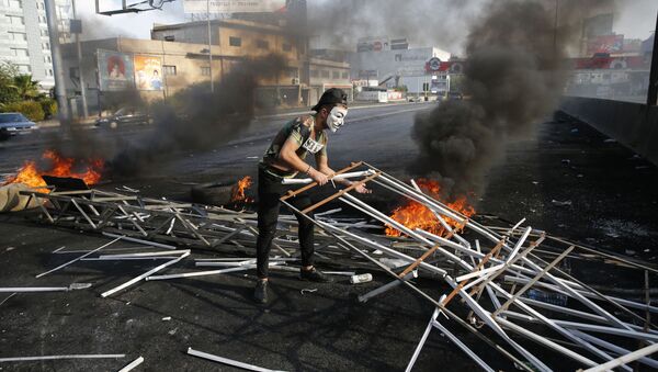 An anti-government protester adds to a makeshift barricade blocking a highway that links to north Lebanon in east Beirut, Lebanon, Sunday, Oct. 20, 2019 - Sputnik International
