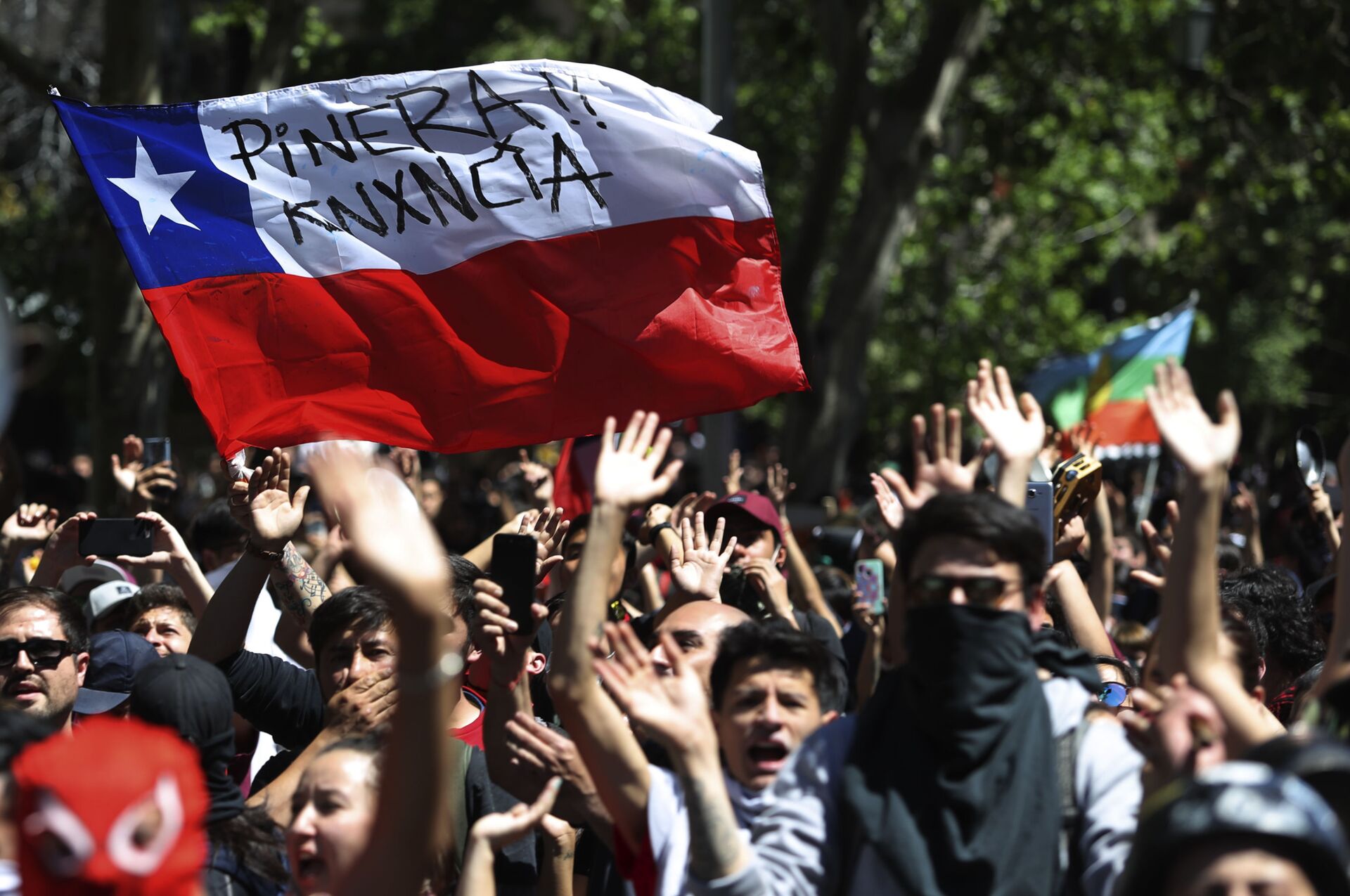 Protesters wave a Chilean flag, marked with a message that reads in Spanish: Pinera quit during a demonstration in Santiago, Chile, Monday, Oct. 21, 2019. - Sputnik International, 1920, 29.08.2022