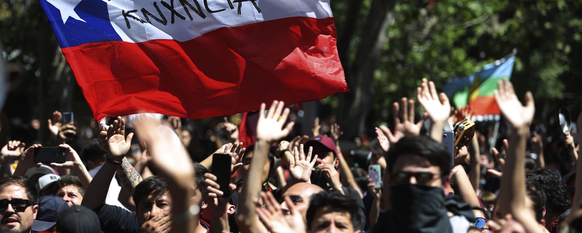 Protesters wave a Chilean flag, marked with a message that reads in Spanish: Pinera quit during a demonstration in Santiago, Chile, Monday, Oct. 21, 2019. - Sputnik International, 1920, 22.01.2022