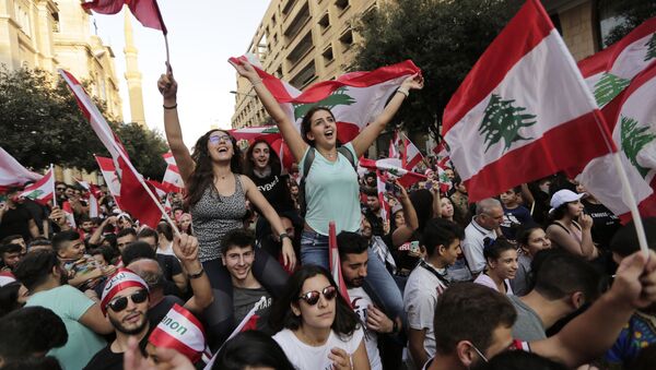 Anti-government protesters shout slogans in Beirut, Lebanon, Sunday, Oct. 20, 2019. Tens of thousands of Lebanese protesters of all ages gathered Sunday in major cities and towns nationwide, with each hour bringing hundreds more people to the streets for the largest anti-government protests yet in four days of demonstrations. - Sputnik International