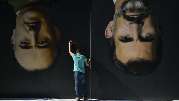 A man sets up upside down giant paintings of late Spanish dictator Francisco Franco, left, and Spanish King Felipe VI ahead of a protest by Basque pro-independence activists in support of Catalonia's independence movement following Spain's conviction of Catalan separatist leaders, in Bilbao, northern Spain, Tuesday, Oct. 15, 2019 - Sputnik International