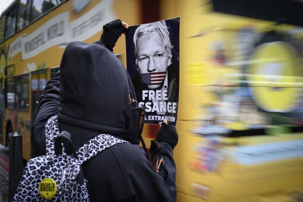 A protester holds a leaflet demanding the release of Julian Assange - Sputnik International