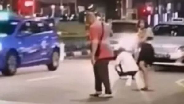 A sceengrab of the clip showing a woman stripping off in the middle of the road in Singapore - Sputnik International