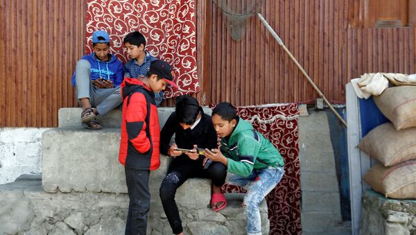 Children play games on their mobile phones in a neighbourhood in Srinagar October 10, 2019 - Sputnik International