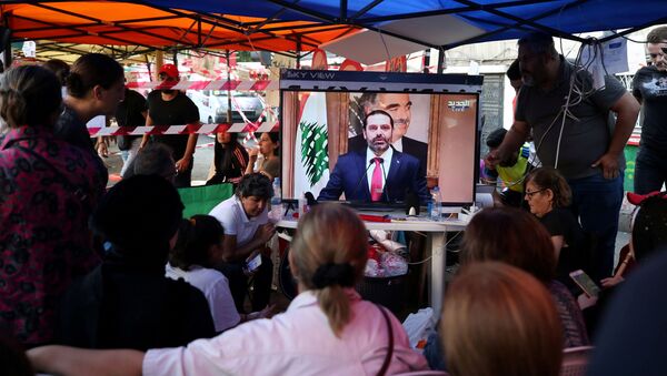 Protestors watch a television broadcast of Lebanon's Prime Minister Saad al-Hariri speaking, in Sidon, Lebanon - Sputnik International