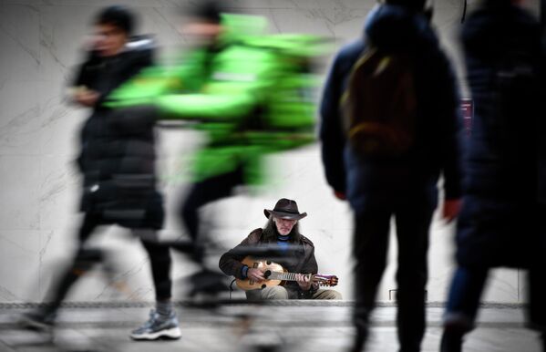 Sergei Sadov, a street musician, plays guitar at the entrance to a metro station in Moscow on October 30, 2019. - Sputnik International