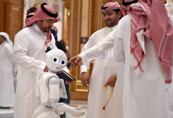 Delegates chat near a robot during the Future Investment Initiative (FII) forum at the King Abdulaziz Conference Centre in Saudi Arabia's capital Riyadh, on October 30, 2019. - Sputnik International