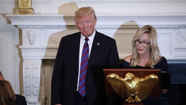 President Donald Trump smiles as pastor Paula White prepares to lead the room in prayer, during a dinner for evangelical leaders in the State Dining Room of the White House, Monday, Aug. 27, 2018, in Washington. - Sputnik International