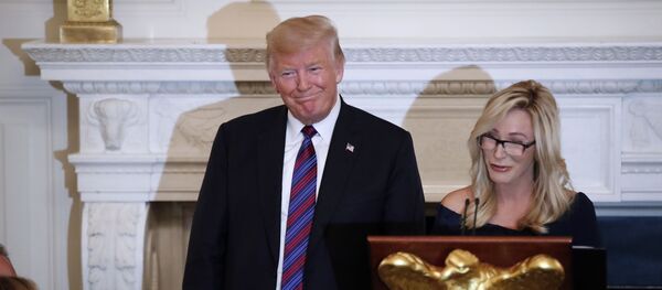 President Donald Trump smiles as pastor Paula White prepares to lead the room in prayer, during a dinner for evangelical leaders in the State Dining Room of the White House, 27 August 2018, in Washington. - Sputnik International