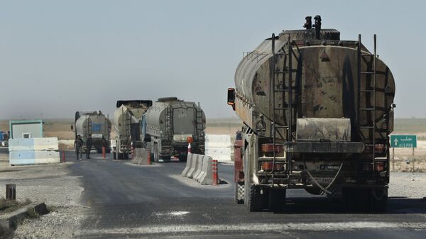 This 4 April 2018 photo, taken on a highway in Syria's Hassakeh province shows a convoy of oil trucks passing a Kurdish police (Assayesh) checkpoint, as they movie fuel produced in Kurdish-held areas in the east to other areas controlled by the U.S-backed group to the west. Since the Syrian government left the predominantly Kurdish area in northern Syria, the Syrian Kurds have been in control of some of the country's largest oil fields in Hassakeh province in the northeast, starting in 2013. Many former government employees stayed on, and their salaries continued to be paid.  - Sputnik International