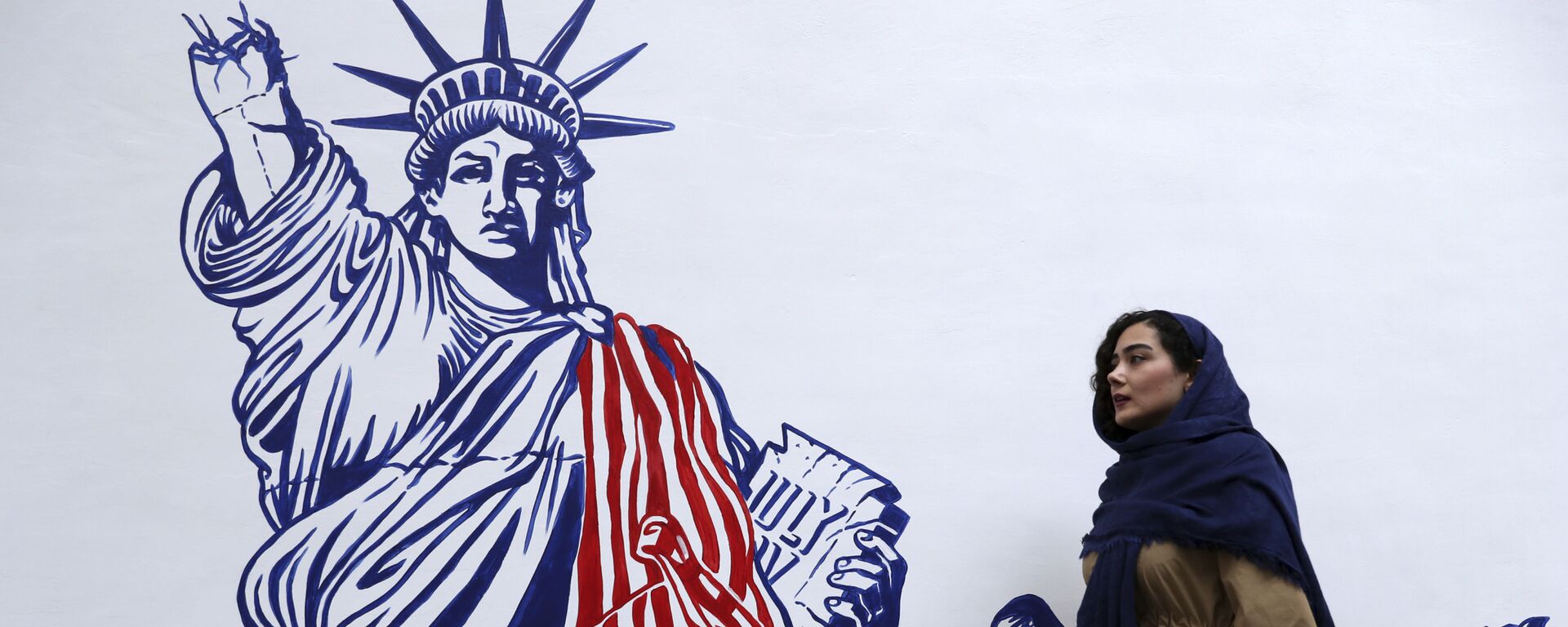 A woman walks past a satirical drawing of the Statue of Liberty after new anti-U.S. murals on the walls of former U.S. embassy unveiled in a ceremony in Tehran, Iran, Saturday, Nov. 2, 2019.  - Sputnik International, 1920, 29.08.2021