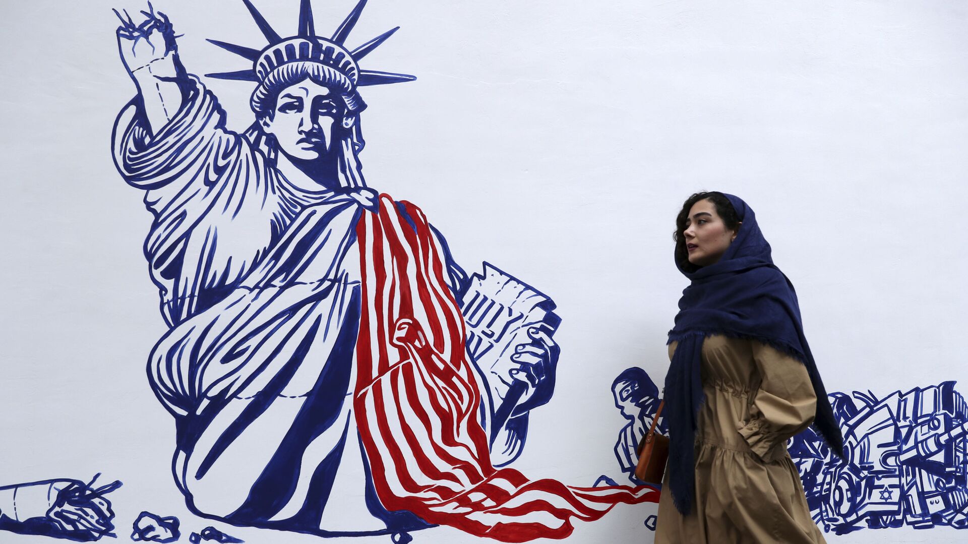 A woman walks past a satirical drawing of the Statue of Liberty after new anti-U.S. murals on the walls of former U.S. embassy unveiled in a ceremony in Tehran, Iran, Saturday, Nov. 2, 2019.  - Sputnik International, 1920, 13.09.2023
