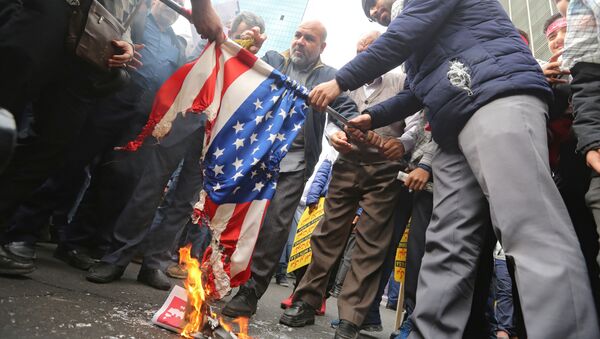 Iranian protesters set a US flag on fire during a rally outside the former US embassy in the Iranian capital Tehran on November 4, 2019, to mark the 40th anniversary of the Iran hostage crisis. - Sputnik International
