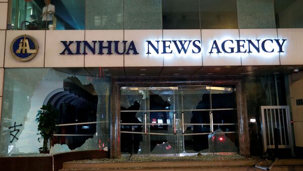 Damaged entrance of China's official Xinhua news agency is seen during anti-government protest in Hong Kong - Sputnik International