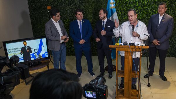 Guatemala's President-elect Alejandro Giammattei, second from right, talks with reporters as National Assembly President and self-proclaimed interim president of Venezuela Juan Guaido is seen on a screen - Sputnik International