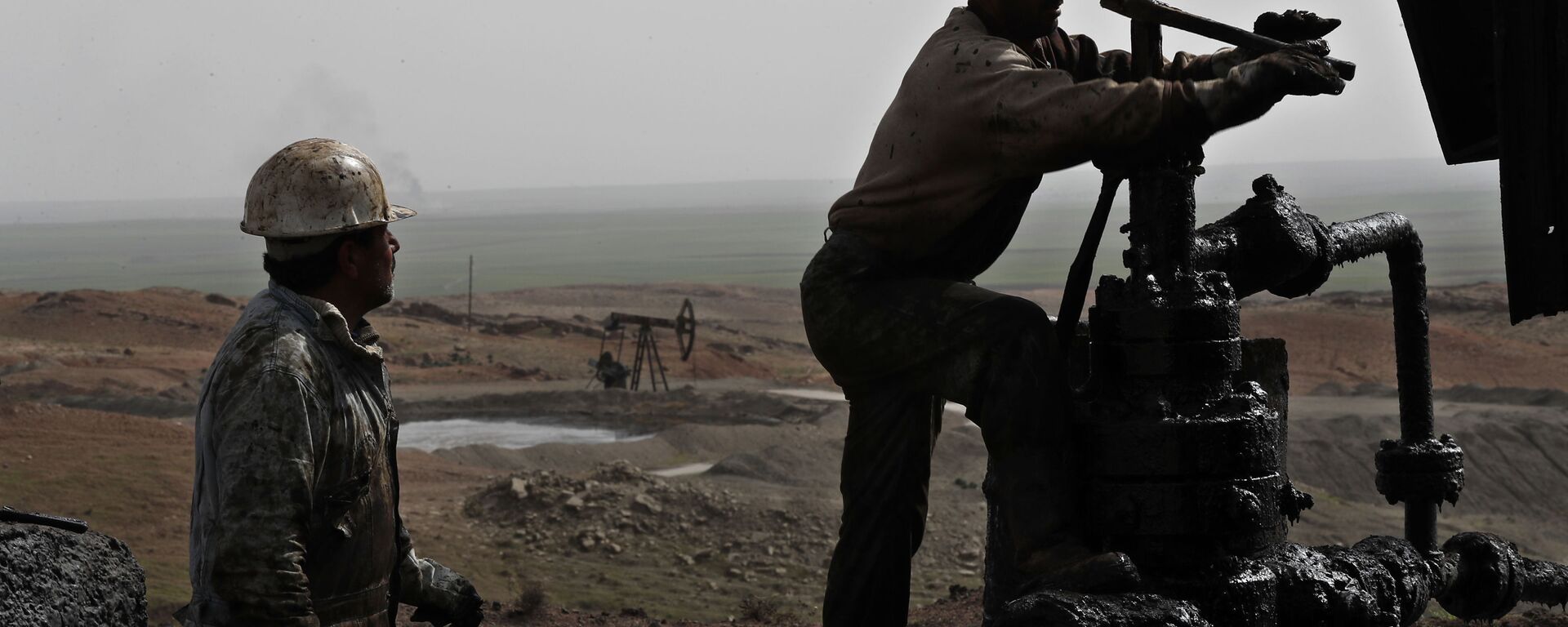 This March 27, 2018 photo shows Syrian workers fixing pipes of an oil well at an oil field controlled by a U.S-backed Kurdish group, in Rmeilan, Hassakeh province, Syria - Sputnik International, 1920, 31.07.2023