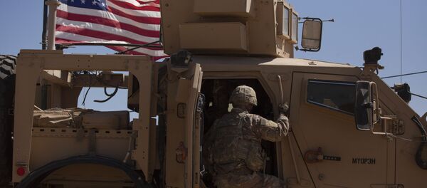 In this Sept. 8, 2019, photo, a U.S. soldier climbs into an armored vehicle during the first American-Turkish joint patrol in the so-called safe zone on the Syrian side of the border with Turkey near Tal Abyad, Syria - Sputnik International