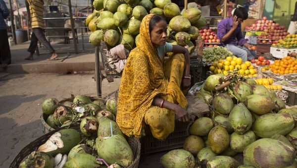 An Indian woman waits for customers as she sells coconuts at a market in Gauhati, India, Wednesday, April 12, 2017. - Sputnik International