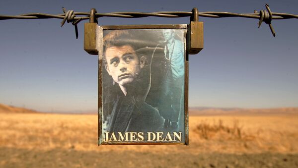 A portrait of U.S. actor James Dean hangs from a fence near the intersection of Highways 46 and 41 near Cholame, California September 30, 2005 - Sputnik International