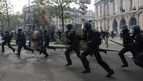 French anti-riot policemen run during clashes with protesters on the sidelines of the annual May Day rally in Paris on May 1, 2019 - Sputnik International