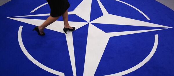 A woman walks across a carpet with the NATO logo ahead of the NATO (North Atlantic Treaty Organization) summit, at the NATO headquarters in Brussels, on July 11, 2018 - Sputnik International