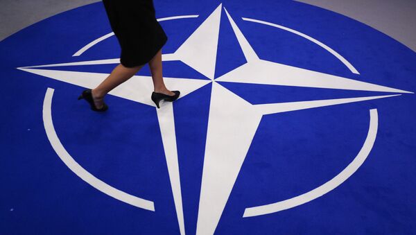 A woman walks across a carpet with the NATO logo ahead of the NATO (North Atlantic Treaty Organization) summit, at the NATO headquarters in Brussels, on July 11, 2018 - Sputnik International